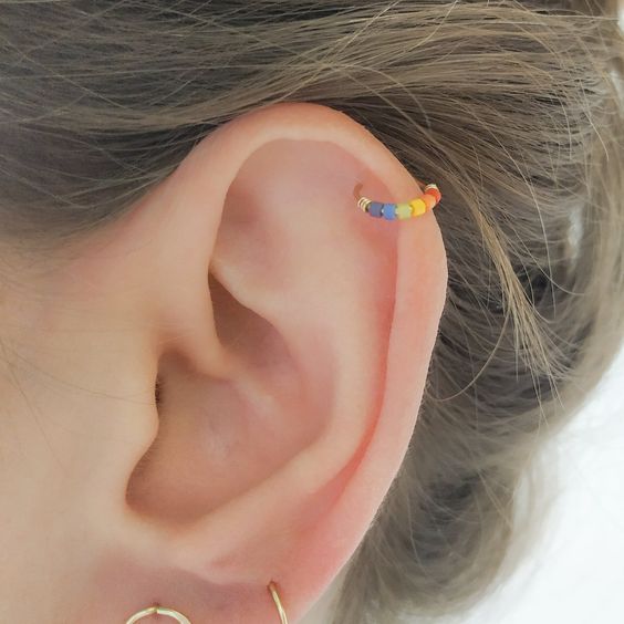 A woman with a colorful ear stud.