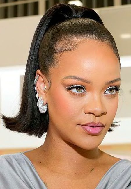 Rihanna with a ponytail and earrings.