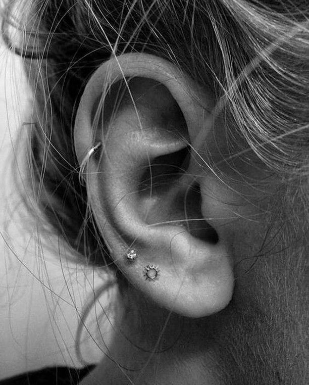 A woman with a small diamond earring in her pierced ear.